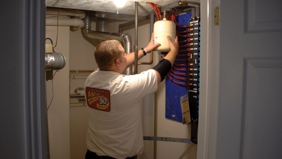 Technician working on an electrical panel in a utility room.