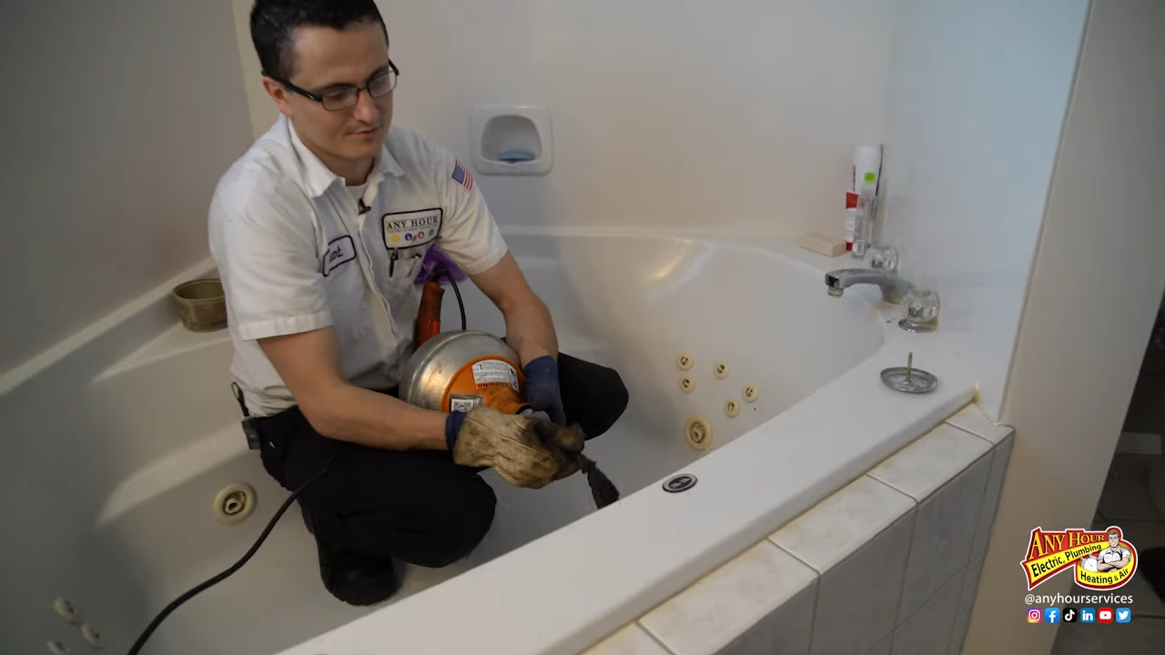 Worker with tools fixing a bathtub.