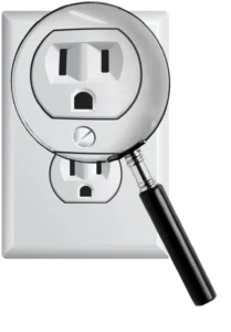 A magnifying glass enlarges an electrical outlet on a wall, emphasizing its details. The image conveys inspection, safety, and attention to detail.
