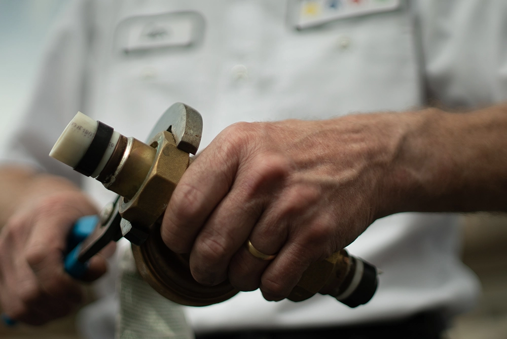 Close up of hands using a wrench to adjust a nut.